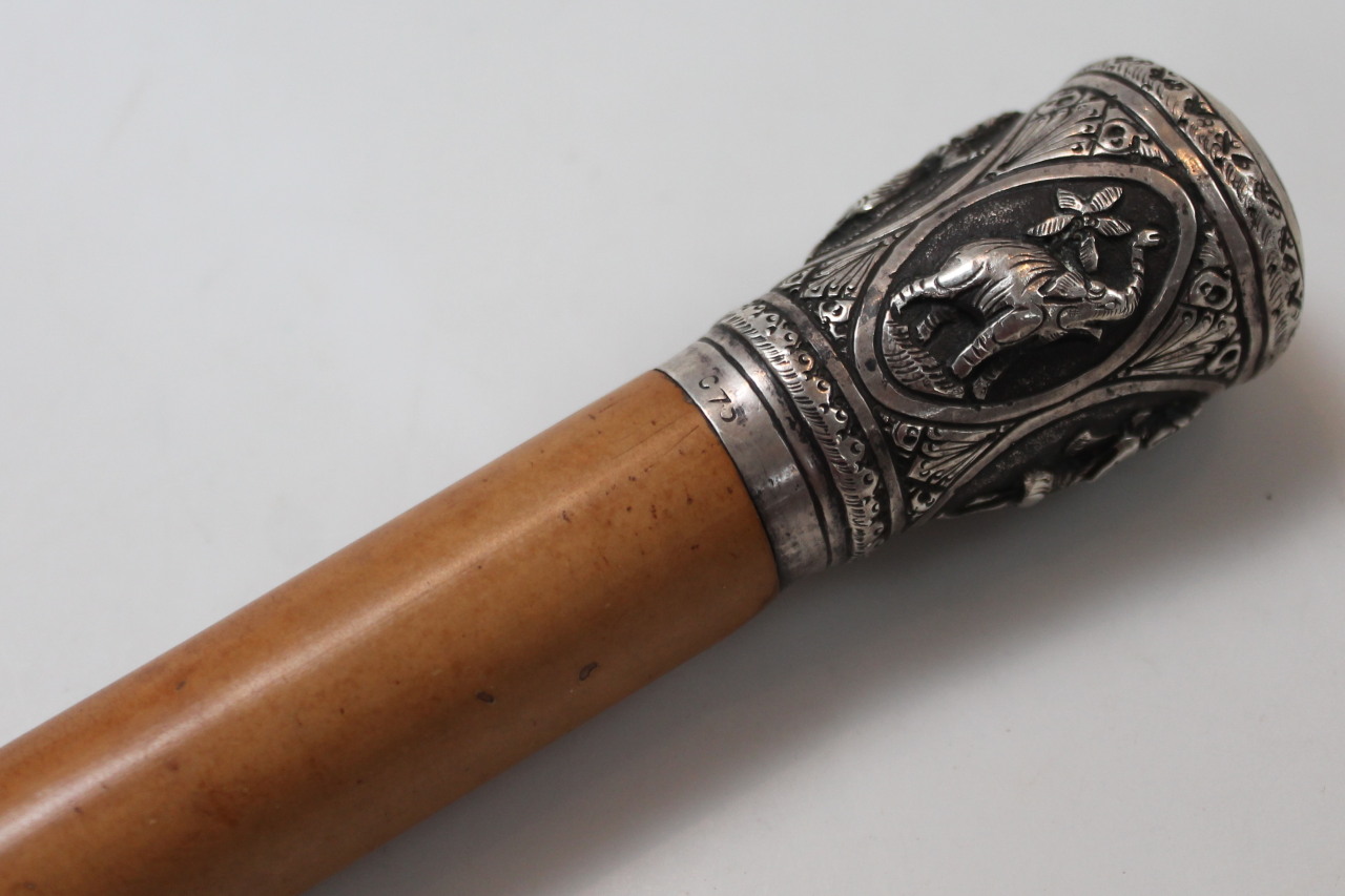 An early 20thC lightwood cane, the cylindrical stem headed by a knop raised with elephants and - Image 2 of 3