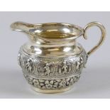 An oriental cream jug, with embossed figures, white metal, marked silver, 8cm high, 5oz.