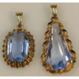 Two similar pendants, the first pear shaped, 4cm high, the other of rounded outline, set with blue