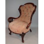 A Victorian mahogany open armchair, with a shaped back carved with flower heads above floral