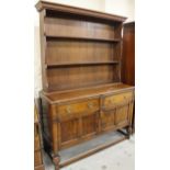 A mid-20thC and later oak dresser, the upper section with a fixed cornice raised above three Delft