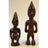 Two Yoruba carved hardwood tribal figures, the first standing with hair up, nude, 29cm high, the