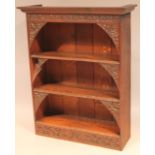 A 20thC Jacobean style oak open shelf, with a overhanging cornice above a heavily carved frieze