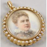 A Victorian portrait locket, set with seed pearls to surround, and figures of a lady and gentleman