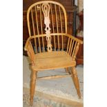 A 20thC stripped pine stained high back Windsor chair, with a pierced splat above a curved arm