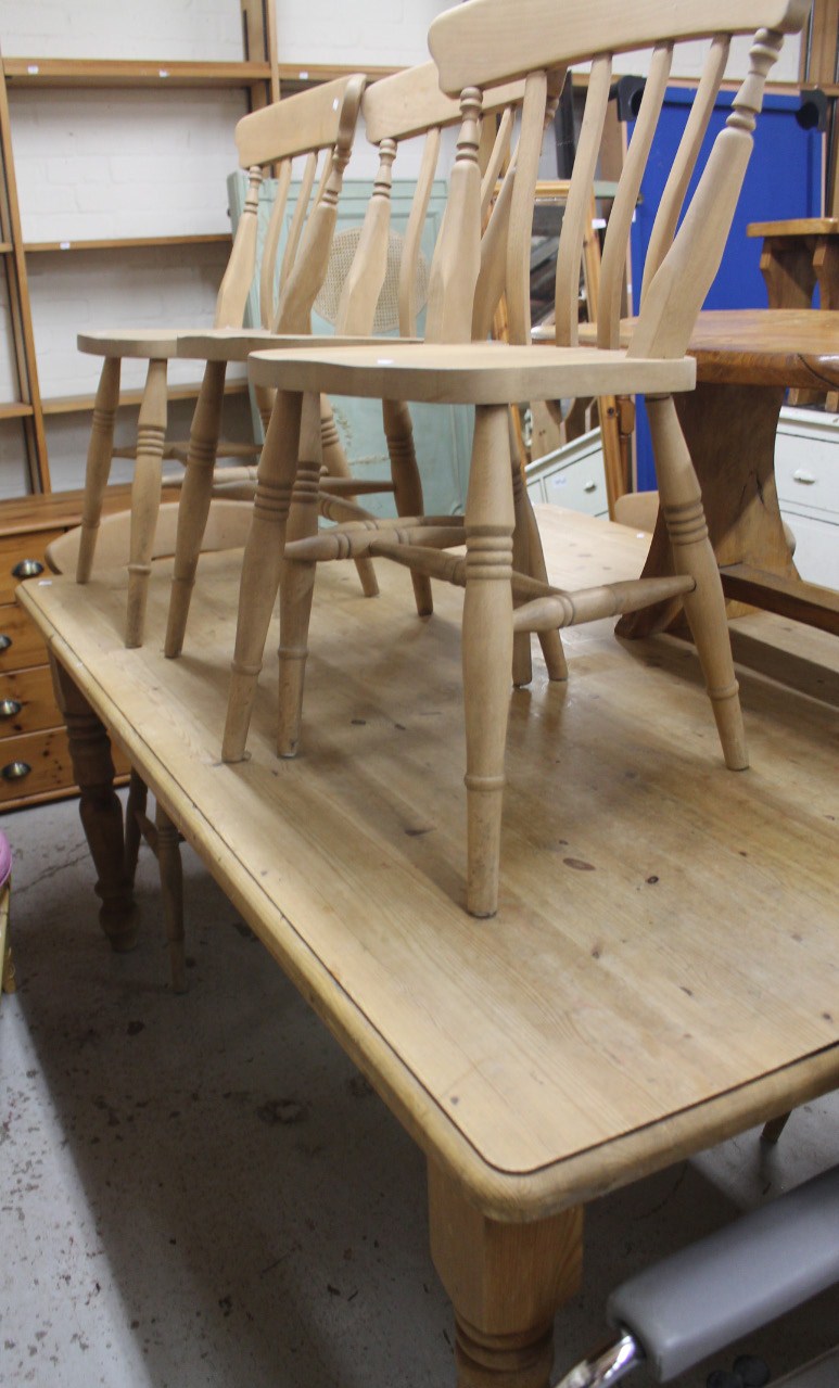 A large 20thC stripped and lightly polished pine kitchen table, the oblong top raised on carved