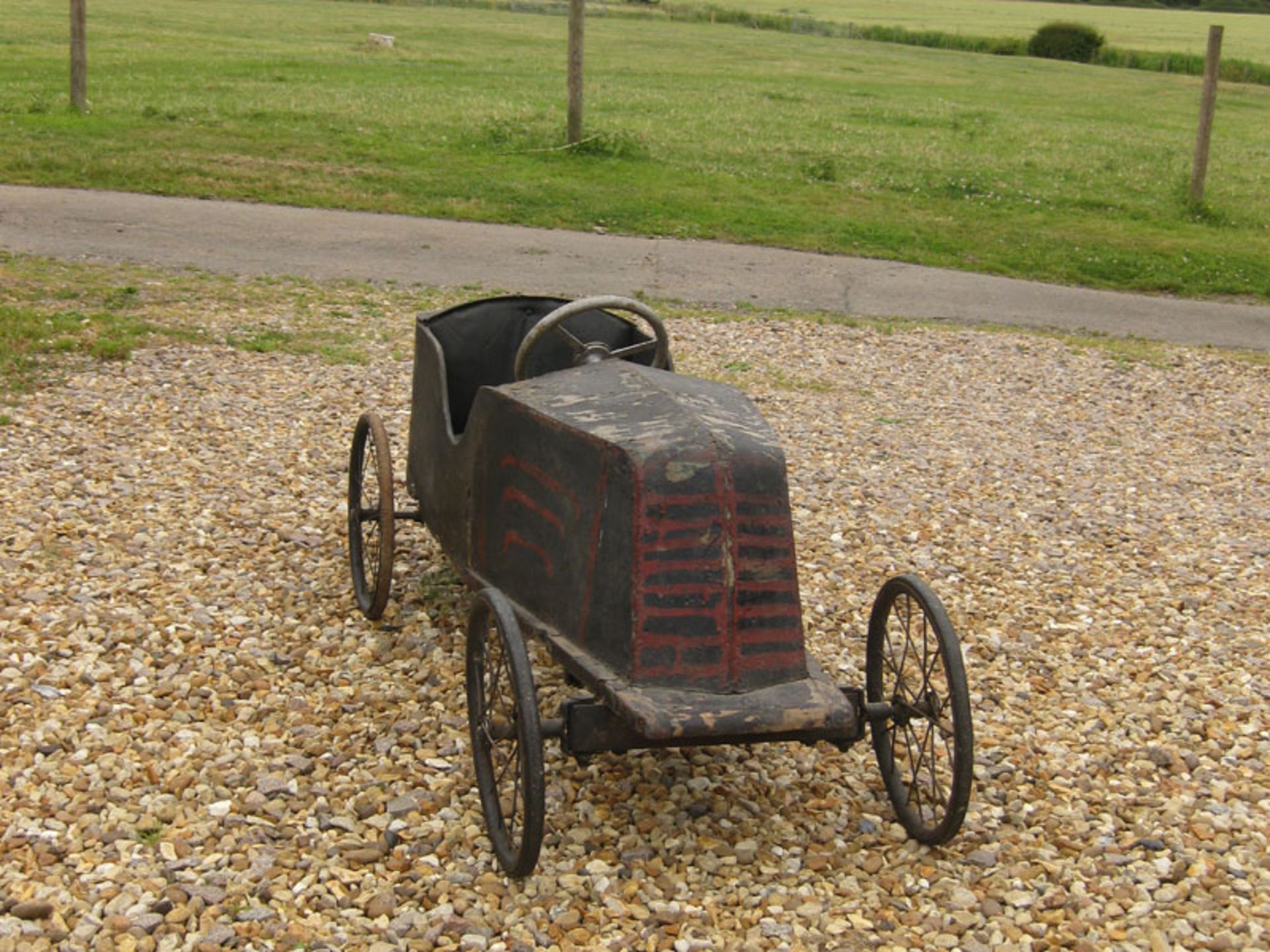 A rare early 20thC childs' pedal-car c1920; of painted plywood panels on wood & metal frame