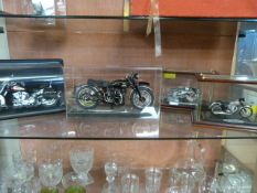 Four cased models of motorbikes including Harley D