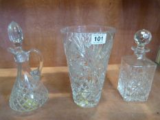 A large cut glass vase and two decanters