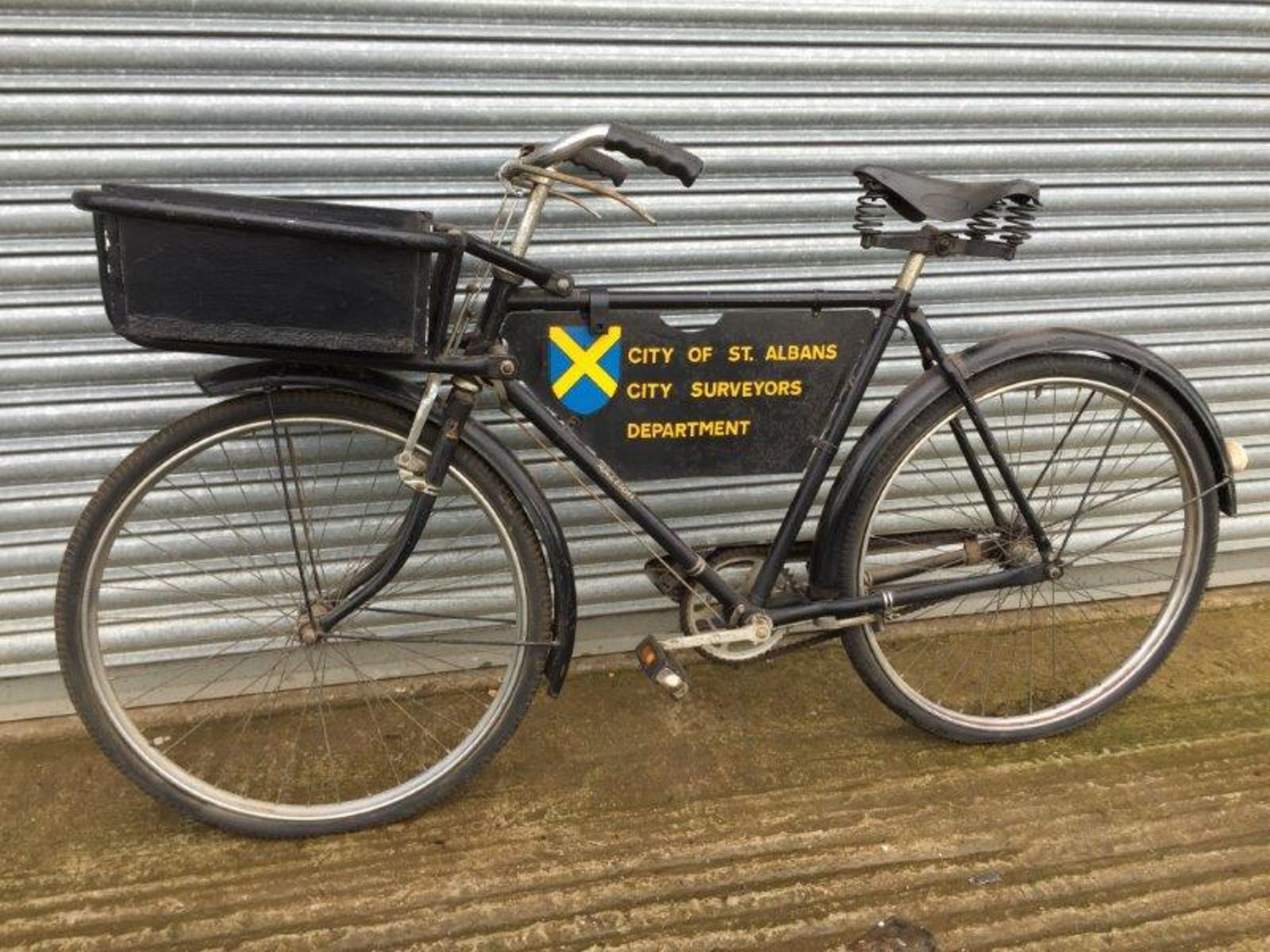 A gents delivery bicycle with 'City of St. Albans City Surveyors Department' sign between the frame,