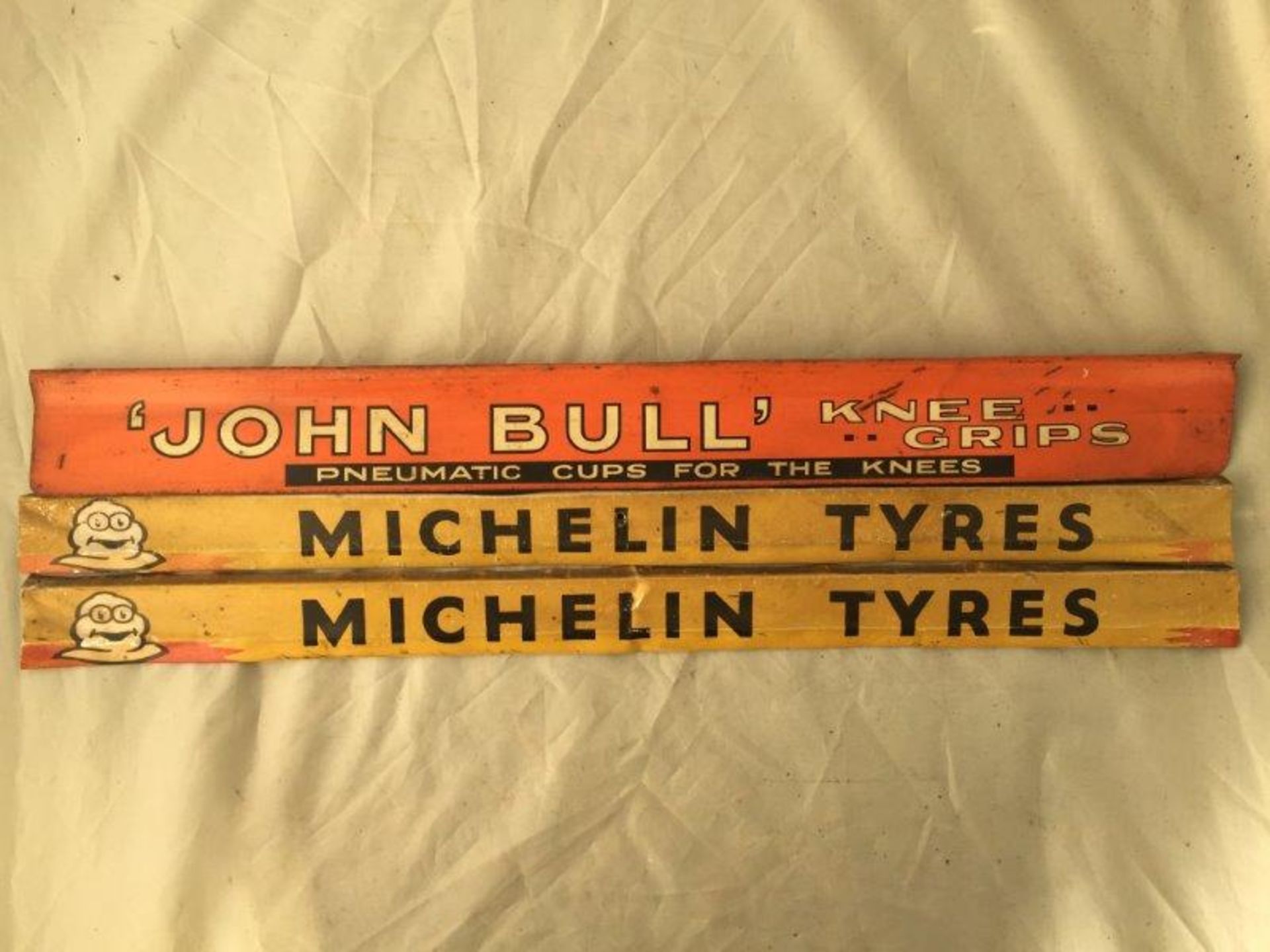 A John Bull knee grips shelf strip and two Michelin Tyres shelf strips.