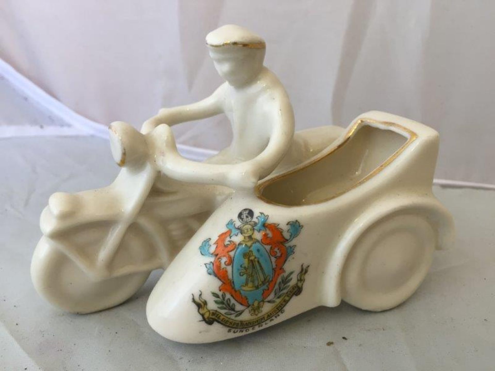 A Carlton China porcelain model of a dispatch rider and side car, with coat of arms for Sunderland.