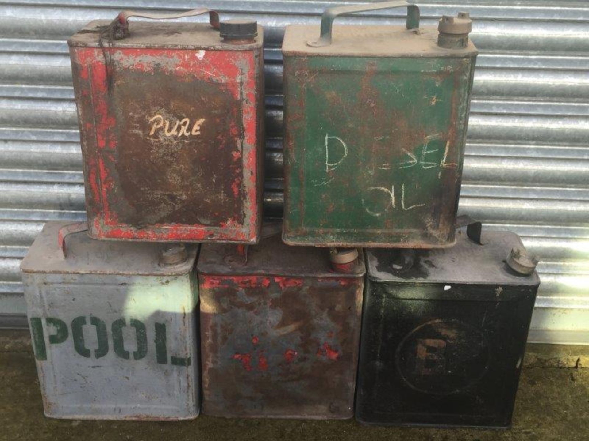 Five assorted two gallon petrol cans including BP.