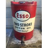 An Esso Two Stroke Motor Oil (self mixing) five gallon cylindrical drum with dispensing tap.