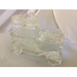 A clear glass condiment set in the form of a motor car.