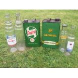 Four glass oil bottles, a Castrol gallon can and a BP gallon can.