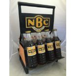 A rare NBC Lubricants eight bottle crate, four bottles to one side with correct labels and caps.