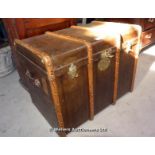 20TH CENTURY WOODEN AND BRASS BOUND TRAVELLING TRUNK WITH LEATHER HANDLES