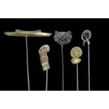 Selection of five stick pins including a cat, a buckle and a gem set stick pin