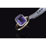 Amethyst and diamond ring, central emerald cut amethyst surrounded by round brilliant cut