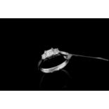 Three stone diamond ring, central step cut diamond, estimated weight 0.30ct, in between two round