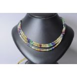 Gem set beaded necklace, three strands of multicoloured gem beads including rubies, emeralds and