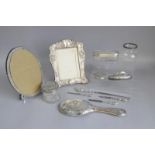 A collection of silver items including two photo frames, a brush back, a glass box with silver
