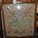 A late Victorian oak framed foliate embroidered fire screen with elaborate brass handle