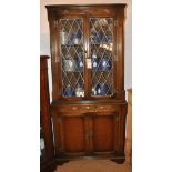 An oak Ercol style glazed corner cabinet, 180cm high