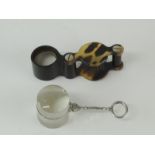 A miniature magnifying glass with white metal handle and a tortoiseshell effect jewellers loupe (2)