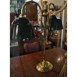 A brass two branch table lamp with dark green shades