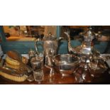 Four silver backed dressing table accessories, small silver trophy and a silver plated three piece