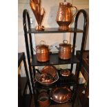 Four shelves containing a good quantity of hammered copper including; storage jars, flower holder