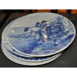 Four Delft blue and white wall plates, depicting Dutch rural and sailing scenes