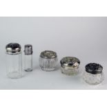 A Victorian silver topped glass bottle, London 1879 and four silver topped cut glass vanity bottles