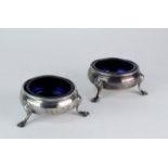 A pair of silver salts by Hester Bateman on three feet, with blue glass liners, London 1786