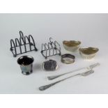Two silver toast racks; a pair of silver boat shaped salts; a silver egg cup; a silver napkin