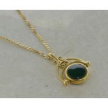 9ct yellow gold fob pendant, set with a green stone to one side and a black stone to the other, on a