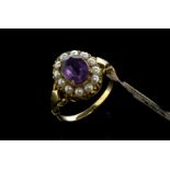 Amethyst and seed pearl cluster ring, central oval cut amethyst, surrounded by twelve white round