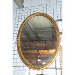 A Victorian oval giltwood mirror with ribbons, 67cm wide, 89cm high