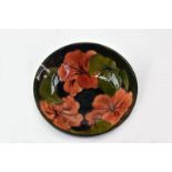 A Moorcroft Hibiscus pattern bowl on green ground, paper label 'By Appointment to Queen Mary',