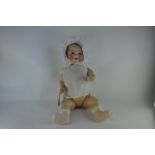 An Armand Marseille 351 bisque headed baby doll, with sleeping blue eyes, open mouth with two teeth,
