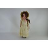 An Armand Marseille 390 bisque headed doll with sleeping brown eyes, open mouth with four teeth,