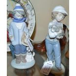 Lladro figure of a boy dressed for winter with spaniel; Nao figure of a girl with puppy.