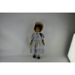 A French celluloid doll, marked SNP in a diamond, with long lashed flirty blue eyes, brown long