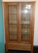 1 x Bentley 'Burr' Oak Illuminated Display Cabinet - 2-Door, 1-Drawer With Glass Shelves &