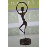 An abstract bronze study of a ballerina in dancing pose standing on a circular base