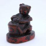 A wood netsuke of a Chinese girl with a seal, 19th centuryWoodcarving netsuke of Chinese girl