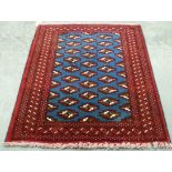 A small red and blue geometric patterned woollen rug, 0.76 x 0.85m.