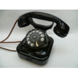 A 1940s style black cradle telephone with hand set.